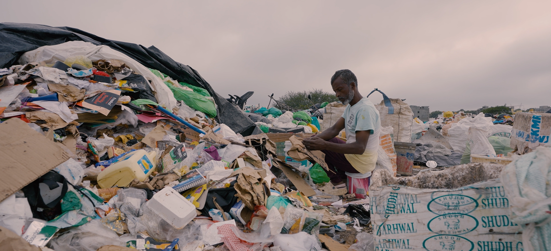 Person sorting plastic waste at a landfill site